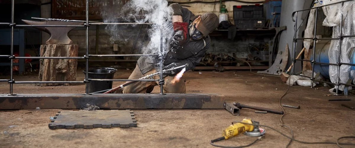 Contractor welding metal used for decorative materials for project