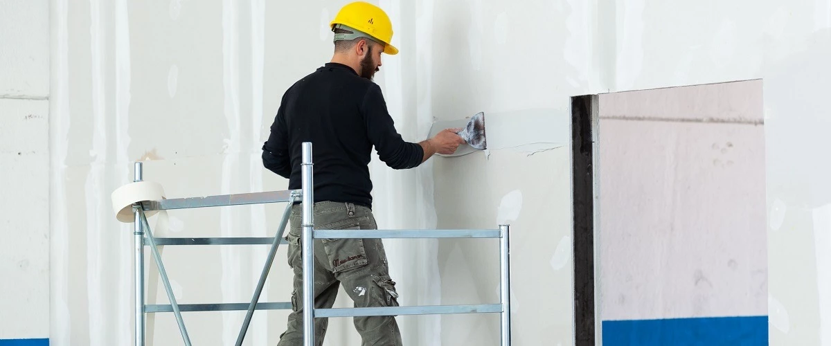 Contractor coating wall with mixture with plastering